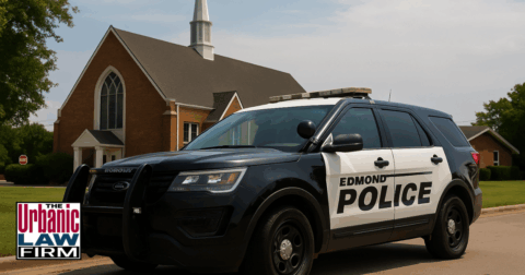 Daytime image of an Edmond police SUV parked in front of a red brick Oklahoma church, representing a trespassing and sexual battery arrest scene.