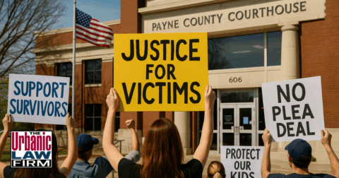 Daytime scene outside the Payne County Courthouse showing protesters holding signs and gathered on the sidewalk, representing community reaction to the Jesse Butler youthful offender case.