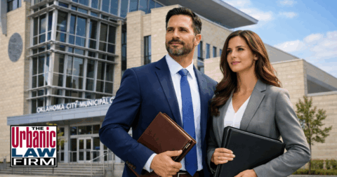 Daytime photo-style image of two suited attorneys standing confidently in front of the Oklahoma City Municipal Courthouse, representing Oklahoma criminal defense services provided by The Urbanic Law Firm.