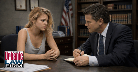 Daytime photograph-style image of a young female college student meeting with an Oklahoma criminal defense attorney in a professional office, illustrating Oklahoma public intoxication criminal defense by The Urbanic Law Firm after an arrest for alcohol-related charges.