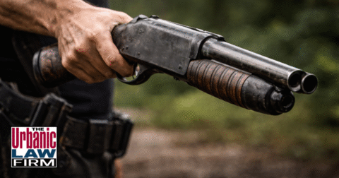 Daytime close-up photograph of an arm holding an altered sawed-off shotgun, visually representing prohibited weapons and restricted ammunition issues in Oklahoma, illustrating how The Urbanic Law Firm provides Oklahoma criminal defense for clients accused of altered firearms and other serious gun crimes.