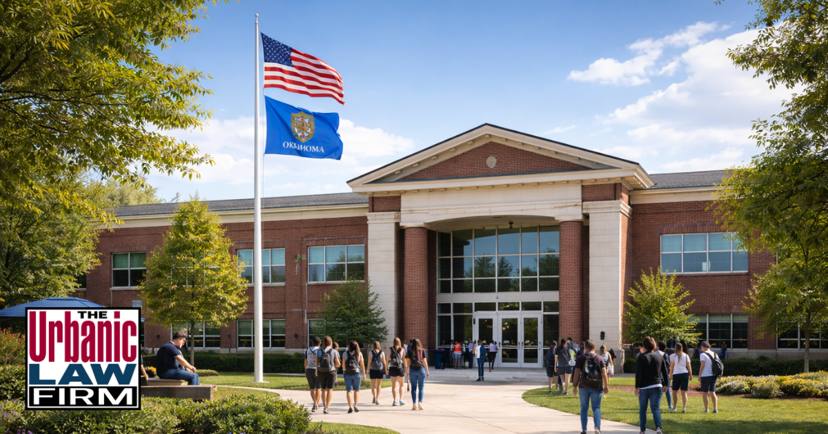 Daytime photograph of an Oklahoma public school exterior with sports facilities in front, highlighting how school and sports situations can lead to assault and battery charges defended by The Urbanic Law Firm, an Oklahoma criminal defense practice.