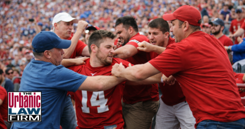 Fans getting into a physical fight at a football game, illustrating battery defense Oklahoma and Oklahoma criminal defense by The Urbanic Law Firm.