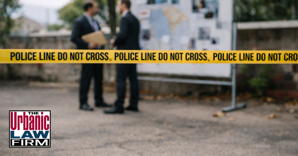 Daytime photograph of an Oklahoma homicide investigation scene with bright yellow POLICE LINE DO NOT CROSS tape in the foreground and two investigators standing near a covered body in the distance, illustrating murder plot attempt crimes investigations and the focused criminal-defense representation provided by The Urbanic Law Firm.