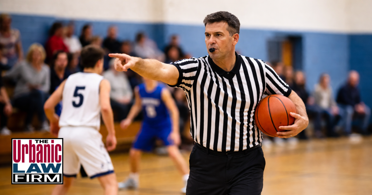 Referee officiating a youth basketball game in Oklahoma, illustrating assault on referee Oklahoma criminal defense issues for The Urbanic Law Firm.