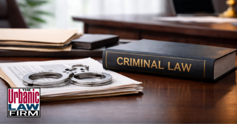 Daytime Oklahoma child sexual abuse criminal defense office scene with legal files, handcuffs, and a criminal law book, illustrating Oklahoma criminal defense by The Urbanic Law Firm.