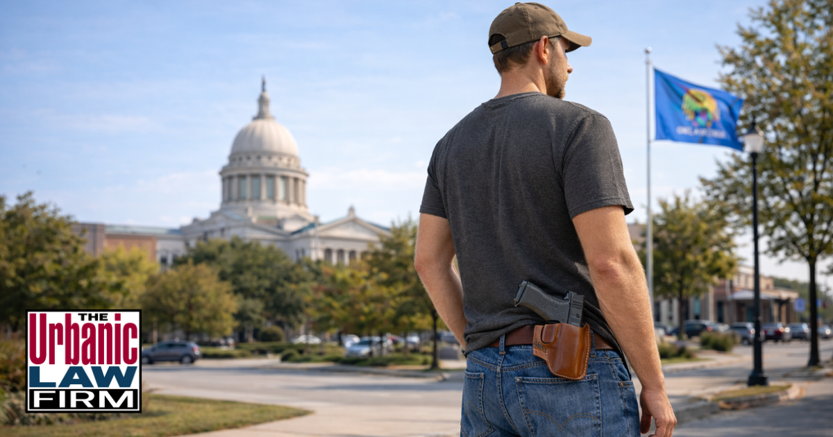 Man with a holstered pistol standing outdoors in Oklahoma near the State Capitol, illustrating Oklahoma constitutional carry and Oklahoma criminal defense by The Urbanic Law Firm.