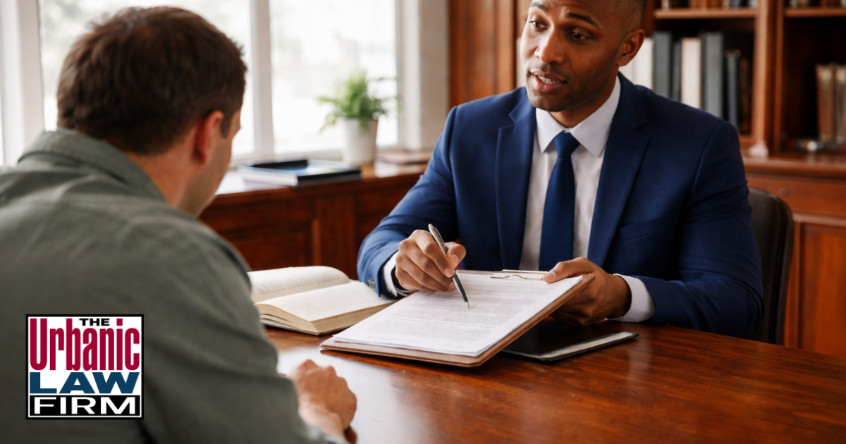 Attorney meeting with a client in a law office, illustrating domestic abuse injury Oklahoma criminal defense representation by The Urbanic Law Firm.