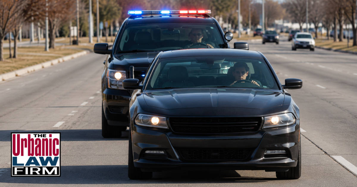 Oklahoma eluding defense image showing a police SUV following a sedan during a daytime traffic stop scene for criminal defense content by The Urbanic Law Firm.