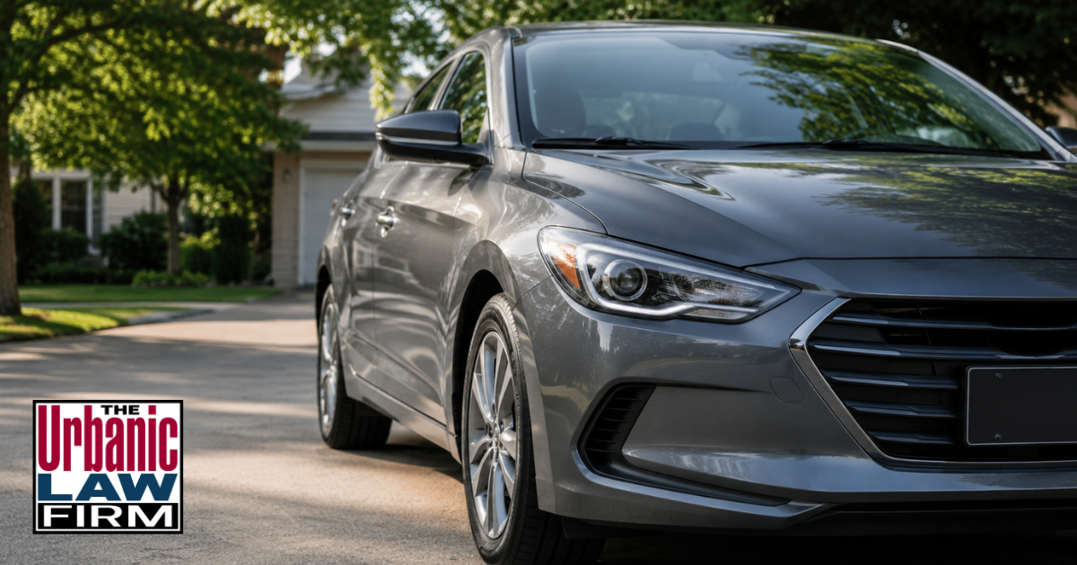 Gray sedan parked in a quiet residential driveway for unauthorized use vehicle Oklahoma criminal defense content by The Urbanic Law Firm.
